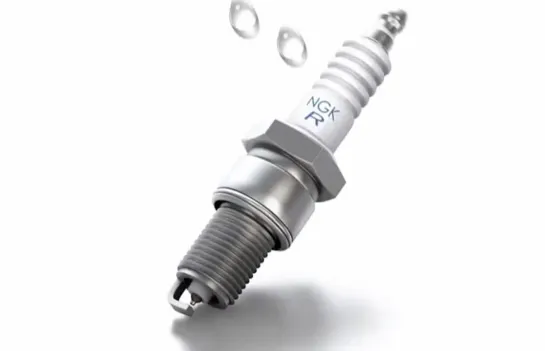 Why does the spark plug insulator need a corrugated surface?