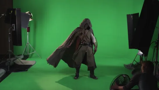 Shot of mysterious hooded medieval archer wearing a cloak with bow in hand. Against green screen.