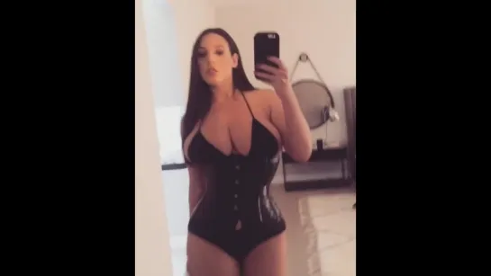 Angela White в латексе подходит к зеркалу и красуется своими огромными дойками