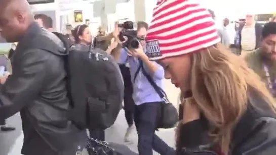 Rihanna Shields Eyes From Cameras In Paparazzi Crowd At LAX