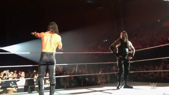 Seth Rollins stands with Roman Reigns in Lille, France