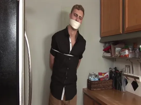 A boy bound & tape gagged in kitchen.