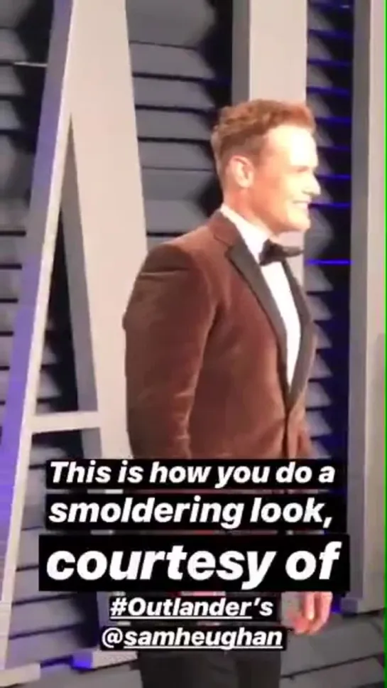 Sam Heughan posing and smiling at Vanity Fair Oscar Party red carpet 2019