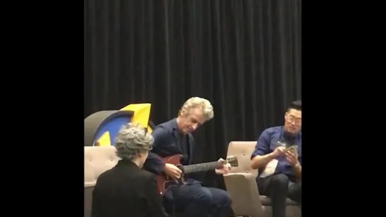 Peter Capaldi playing a guitar