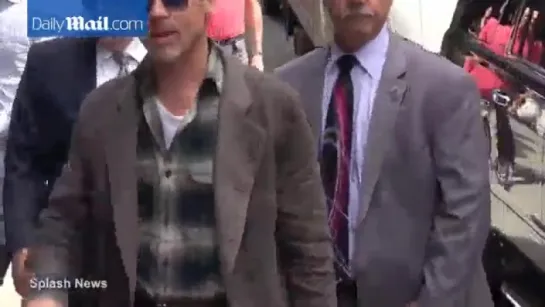 Brad Pitt waves to fans as he arrives at The Late Show with Stephen Colbert