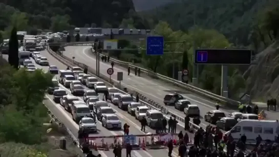 Hundreds of Catalan protesters block a highway that connects the Spanish region with France