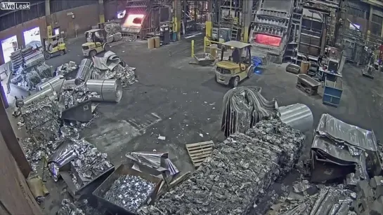 Foundry worker puts wet scrap metal in furnace