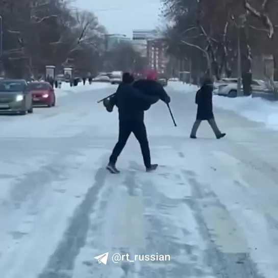 Мужчина перенёс пожилую женщину на руках через заснеженную и скользкую дорогу в Москве