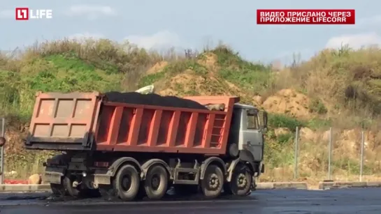 Грузовик дорожных служб проехался по только что уложенному асфальту