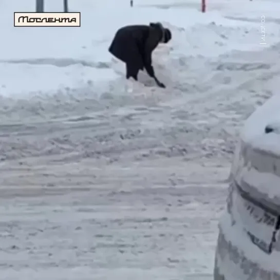 Пенсионерка расчищает дорожку от снега