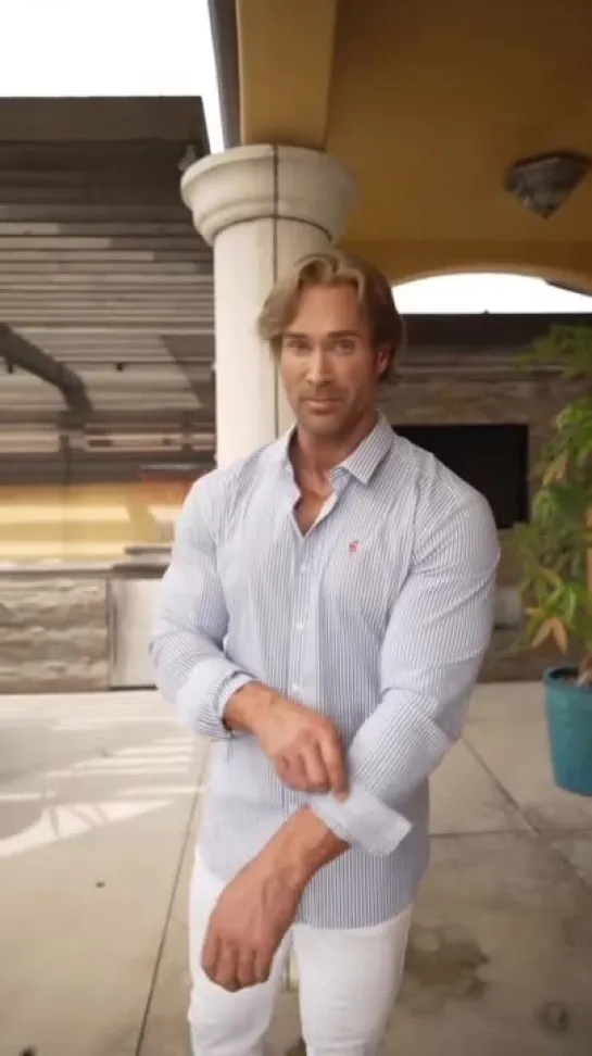 Mike OHearn поправляет рукав рубашки, а затем приятно улыбается