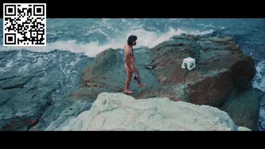 A melancholic guy drinks wine next to ocean