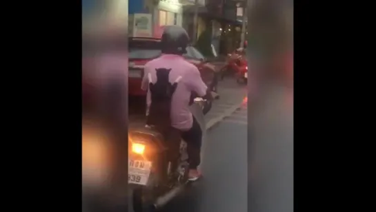 A cat riding a motorbike. This isn't something you see every day!