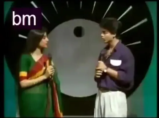 Shah Rukh Khan as a tv anchor in a singing show of Doordarshan