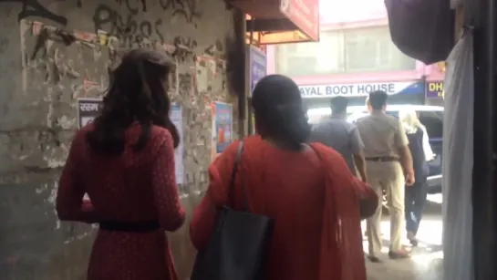 The Duchess walks through a narrow Delhi street